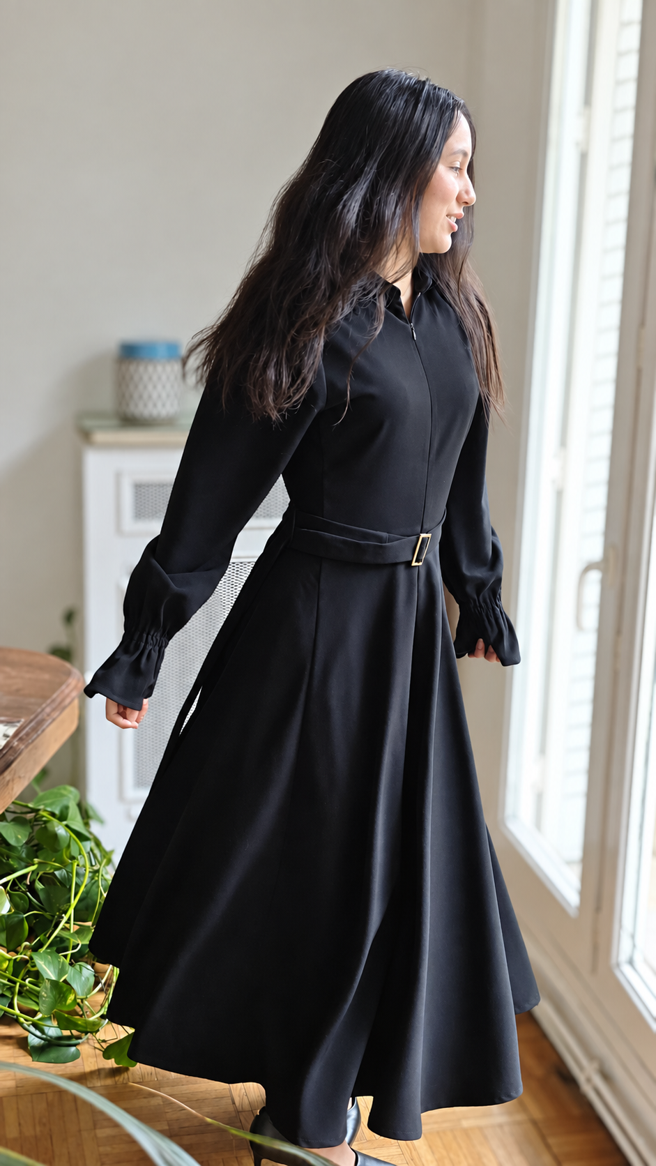 Robe Signature longue noire près d’une fenêtre